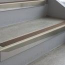 Mirroflect Silver deep-riser square-edge aluminium stair nosing fitted along two bare concrete steps, 62mm tread plate and 56mm front face, with a Brown anti-slip insert running the full width of each step
