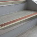 Mirroflect Silver deep-riser square-edge aluminium stair nosing fitted along two bare concrete steps, 62mm tread plate and 56mm front face, with a Mid Brown anti-slip insert running the full width of each step