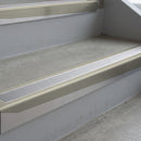 Mirroflect Silver deep-riser square-edge aluminium stair nosing fitted along two bare concrete steps, 62mm tread plate and 56mm front face, with a Polar Grey anti-slip insert running the full width of each step