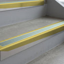Mirrorflect Gold deep-riser square-edge aluminium stair nosing fitted along two bare concrete steps, 62mm tread plate and 56mm front face, with a Sage Green anti-slip insert running the full width of each step