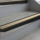 Satin Black deep-riser square-edge aluminium stair nosing fitted along two bare concrete steps, 62mm tread plate and 56mm front face, with a Beige anti-slip insert running the full width of each step