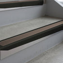 Satin Black deep-riser square-edge aluminium stair nosing fitted along two bare concrete steps, 62mm tread plate and 56mm front face, with a Brown anti-slip insert running the full width of each step