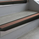 Satin Black deep-riser square-edge aluminium stair nosing fitted along two bare concrete steps, 62mm tread plate and 56mm front face, with a Mid Brown anti-slip insert running the full width of each step