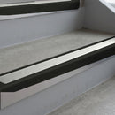 Satin Black deep-riser square-edge aluminium stair nosing fitted along two bare concrete steps, 62mm tread plate and 56mm front face, with a Oyster anti-slip insert running the full width of each step