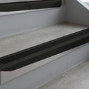 Satin Black deep-riser square-edge aluminium stair nosing fitted along two bare concrete steps, 62mm tread plate and 56mm front face, with a Premium Black anti-slip insert running the full width of each step