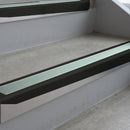 Satin Black deep-riser square-edge aluminium stair nosing fitted along two bare concrete steps, 62mm tread plate and 56mm front face, with a Sage Green anti-slip insert running the full width of each step