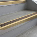 Satin Bronze deep-riser square-edge aluminium stair nosing fitted along two bare concrete steps, 62mm tread plate and 56mm front face, with a Brown anti-slip insert running the full width of each step