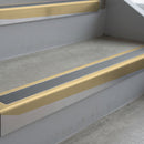 Satin Bronze deep-riser square-edge aluminium stair nosing fitted along two bare concrete steps, 62mm tread plate and 56mm front face, with a Mid Grey anti-slip insert running the full width of each step