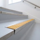 Mill finish aluminium stair nosing with brimstone insert on pale grey vinyl treads in a health centre stairwell