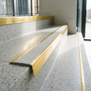 Mirrorflect gold aluminium stair nosing with everest insert on light terrazzo treads in an apartment lobby stair