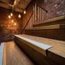 Satin gold aluminium stair nosing with everest insert on oak treads in a restaurant mezzanine staircase