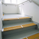 Mill finish double channel stair nosings with twin brimstone anti-slip inserts on pale vinyl hospital stair treads