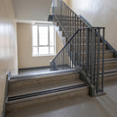 Mill finish double channel aluminium stair nosings with twin coal anti-slip inserts on concrete school stairwell treads