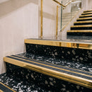 Mirrorflect gold double channel stair nosings with twin coal anti-slip inserts on black terrazzo retail store stair treads