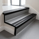 Satin black double channel stair nosings with twin coal anti-slip inserts on grey vinyl office stair treads