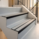 Satin black double channel stair nosings with twin everest anti-slip inserts on pale lino apartment stair treads