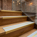 Satin gold double channel stair nosings with twin everest anti-slip inserts on oak restaurant mezzanine stair treads