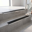 Square-edge aluminium stair nosing fitted directly to bare concrete steps with no floor covering, showing the full profile - flat tread plate, tapered rear edge and square front face down the riser
