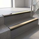 Satin Black aluminium stair nosing fitted along two concrete steps in an office stairwell, with a Beige anti-slip insert running the full width of each step