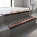 Satin Black aluminium stair nosing fitted along two concrete steps in an office stairwell, with a Mid Brown anti-slip insert running the full width of each step