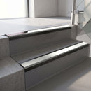 Satin Black aluminium stair nosing fitted along two concrete steps in an office stairwell, with an Oyster anti-slip insert running the full width of each step