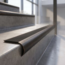 Antique Bronze finish - solid brass raked back stair nosing with black anti-slip insert fitted on concrete steps
