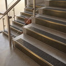 Antique Brass finish with Black Olympic Grip insert - 59.5mm solid brass raked front single channel stair nosing fitted to a stone step