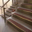 Antique Brass finish with Claret Castellated insert - 59.5mm solid brass raked front single channel stair nosing fitted to a stone step