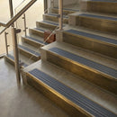 Antique Brass finish with Nimbus Castellated insert - 59.5mm solid brass raked front single channel stair nosing fitted to a stone step