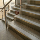 Antique Brass finish with Polar Grey Smooth Textured insert - 59.5mm solid brass raked front single channel stair nosing fitted to a stone step