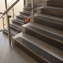 Antique Bronze finish with Black Olympic Grip insert - 59.5mm solid brass raked front single channel stair nosing fitted to a stone step