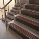 Antique Bronze finish with Claret Castellated insert - 59.5mm solid brass raked front single channel stair nosing fitted to a stone step