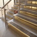 Polished Brass finish with Antique Bronze insert - 59.5mm solid brass raked front single channel stair nosing fitted to a stone step
