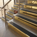 Polished Brass finish with Black Smooth Textured insert - 59.5mm solid brass raked front single channel stair nosing fitted to a stone step
