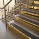 Polished Brass finish with Black Olympic Grip insert - 59.5mm solid brass raked front single channel stair nosing fitted to a stone step