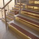 Polished Brass finish with Claret Castellated insert - 59.5mm solid brass raked front single channel stair nosing fitted to a stone step