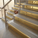 Polished Brass finish with Light Grey Castellated insert - 59.5mm solid brass raked front single channel stair nosing fitted to a stone step