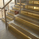Polished Brass finish with Olive Castellated insert - 59.5mm solid brass raked front single channel stair nosing fitted to a stone step