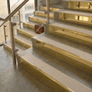 Polished Brass finish with Porth Stone Smooth Textured insert - 59.5mm solid brass raked front single channel stair nosing fitted to a stone step