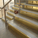 Polished Brass finish with Polar Grey Smooth Textured insert - 59.5mm solid brass raked front single channel stair nosing fitted to a stone step