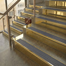 Polished Brass finish with Regency Castellated insert - 59.5mm solid brass raked front single channel stair nosing fitted to a stone step