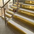 Polished Brass finish with White Castellated insert - 59.5mm solid brass raked front single channel stair nosing fitted to a stone step