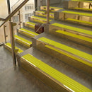 Polished Brass finish with Yellow Castellated insert - 59.5mm solid brass raked front single channel stair nosing fitted to a stone step