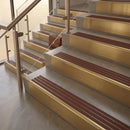 Satin Brass finish with Claret Castellated insert - 59.5mm solid brass raked front single channel stair nosing fitted to a stone step