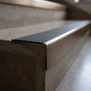 Solid Brass Stair Nosing 59.5mm Square Front with Single Channel in antique bronze finish fitted on a step edge