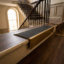 Solid brass stair nosing 59mm raked back slimline in antique brass finish with black olympic grip anti-slip insert, fitted to a stair tread