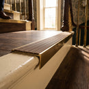 Solid brass stair nosing 59mm raked back slimline in antique brass finish with fawn castellated anti-slip insert, fitted to a stair tread