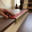 Solid brass stair nosing 59mm raked back slimline in antique brass finish with poppy castellated anti-slip insert, fitted to a stair tread