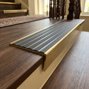 Solid brass stair nosing 59mm raked back slimline in antique brass finish with regency castellated anti-slip insert, fitted to a stair tread