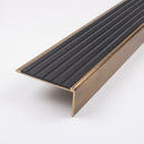 Solid brass stair nosing 59mm raked back slimline profile in antique brass finish with black castellated insert, studio view